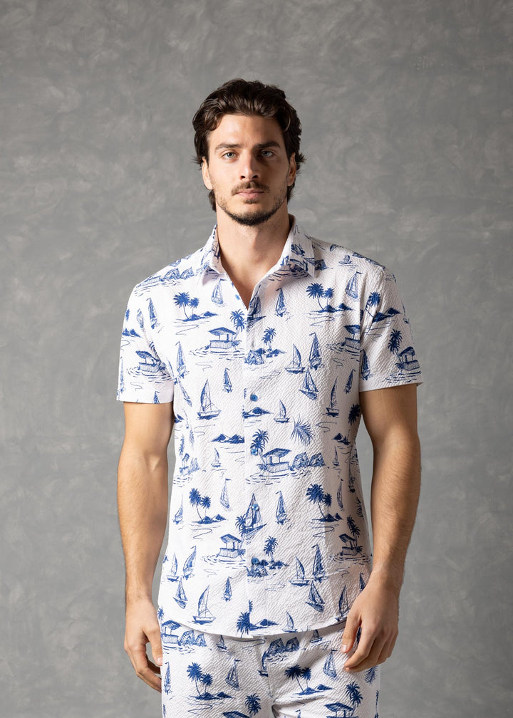 Man wearing a white shirt and shorts with blue patterns against a gray background